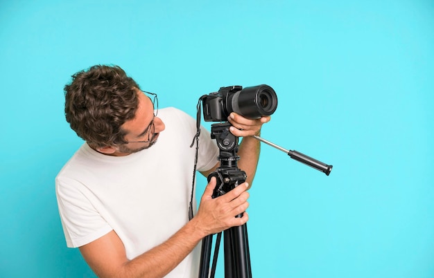 Giovane pazzo barbuto ed espressivo con un concetto di fotografo di macchina fotografica