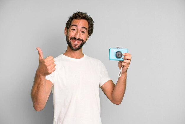Photo young crazy bearded and expressive man with a vintage phooto camera