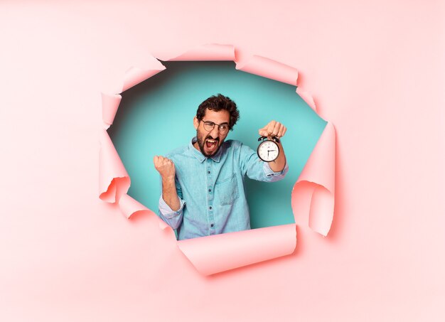 Young crazy bearded man. alarm clock concept