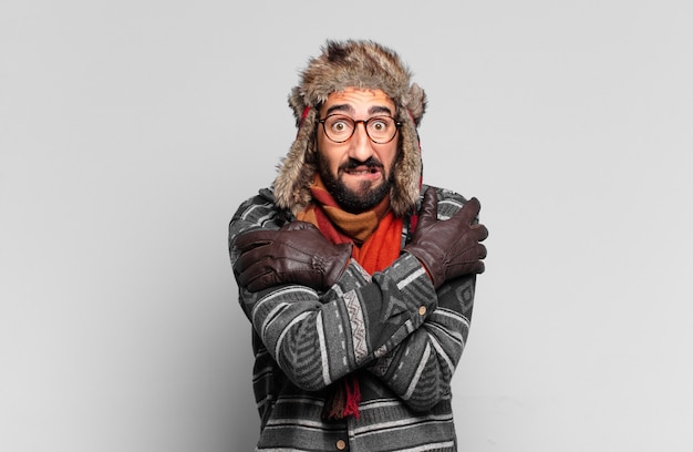 Фото Молодой сумасшедший бородатый мужчина в зимней одежде