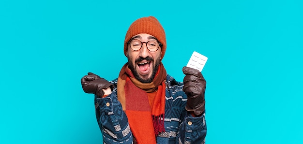 Young crazy bearded man. celebrating a triumph like a winner and wearing winter clothes