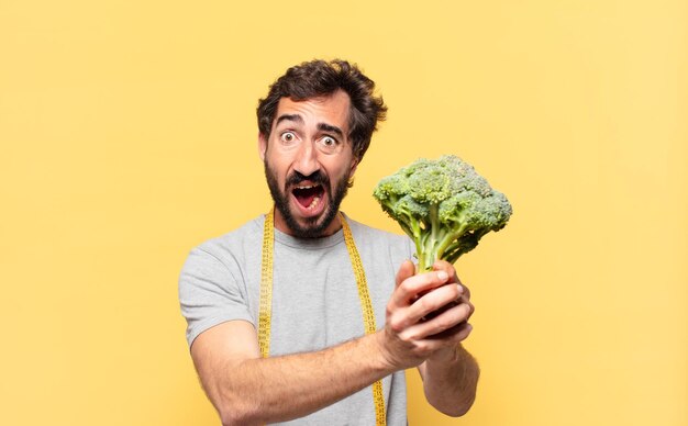 Young crazy bearded man dieting sad expression and holding a cabbage