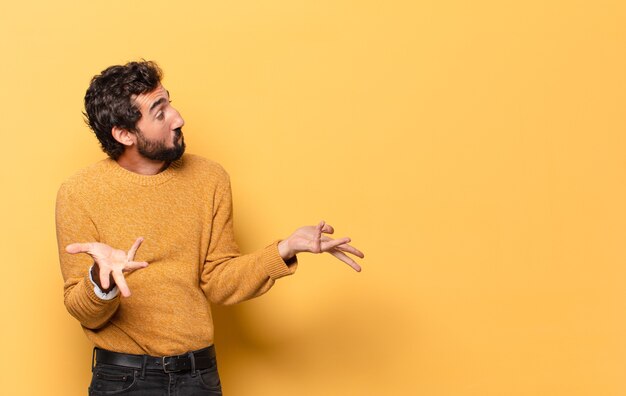 Young crazy bearded man expressing with a copy space.