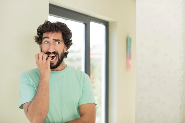 young crazy bearded man feeling terrified in horror and panic