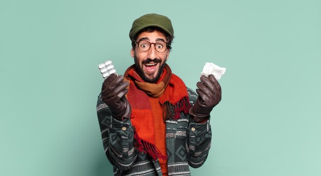 Young crazy bearded man. happy and surprised expression and wearing winter clothes. illness concept