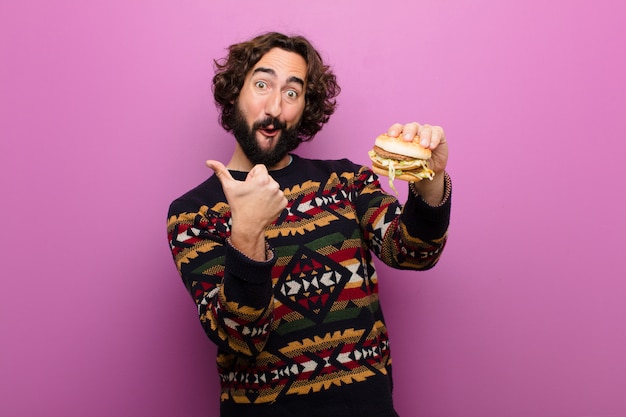Young crazy bearded man having a burger