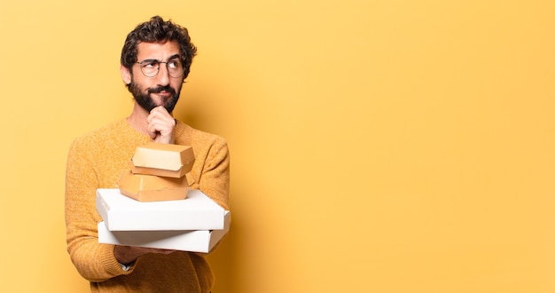 Young crazy bearded man having take away fast food with a copy space