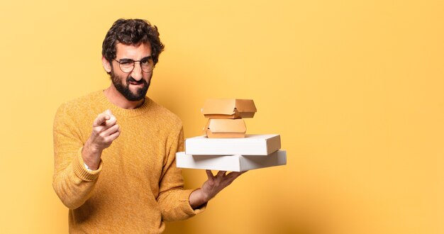 Young crazy bearded man having take away fast food with a copy space