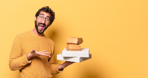 Young crazy bearded man having take away fast food with a copy space