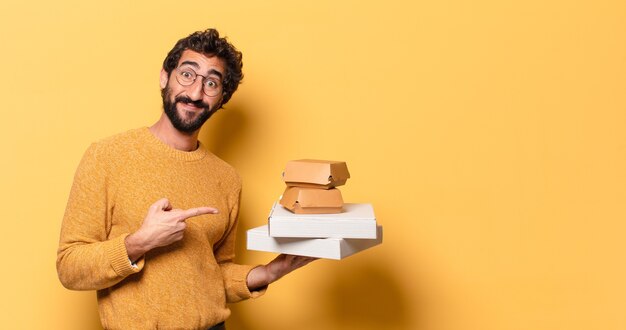 Young crazy bearded man having take away fast food with a copy space