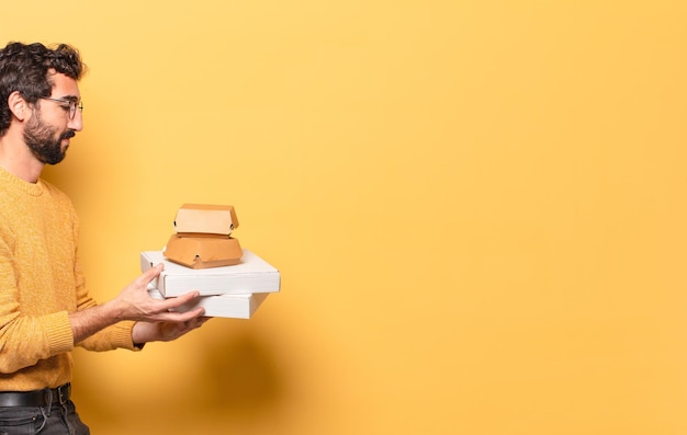 Young crazy bearded man having take away fast food with a copy space