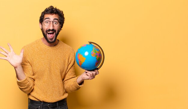 Young crazy bearded man holding a world globe map