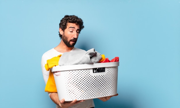 Young crazy bearded man housekeeping washing clothes