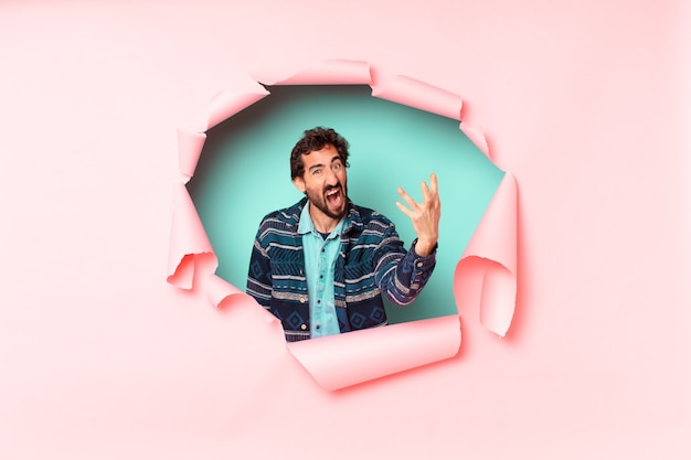 Young crazy bearded man. paper hole empty background concept