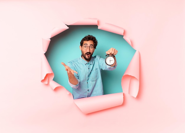 Young crazy bearded man. shocked or surprised expression. alarm clock concept