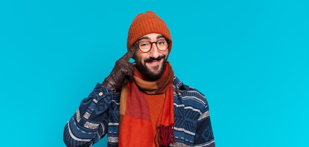 Young crazy bearded man. thinking or doubting expression and wearing winter clothes