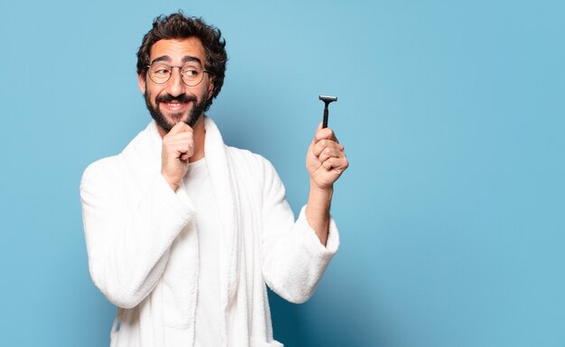 Young crazy bearded man wearing bathrobe. shaving concept