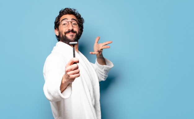 Young crazy bearded man wearing bathrobe. shaving concept