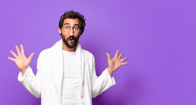 Young crazy bearded man wearing bathrobe and waking up at home