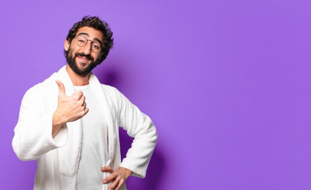 Young crazy bearded man wearing bathrobe and waking up at home