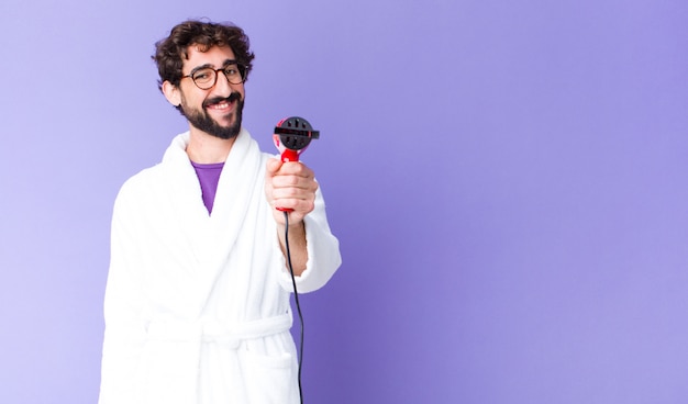 Young crazy bearded man wearing bathrobe with a hairdresser