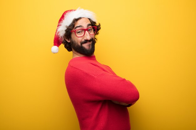 Young crazy bearded man wearing red glasses and santa claus hat 