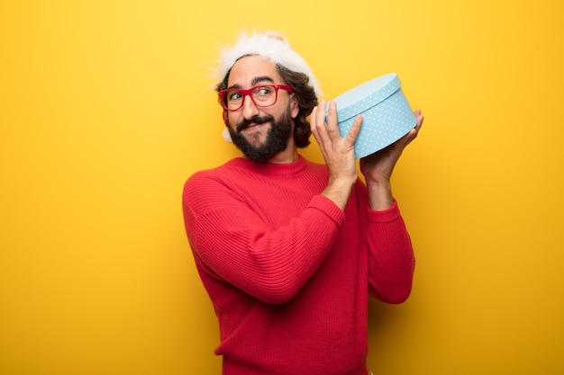 Photo young crazy bearded man wearing red glasses and santa claus hat