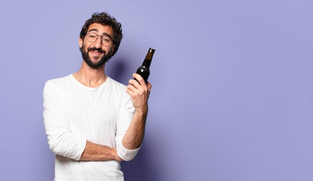 Giovane uomo barbuto pazzo con una birra