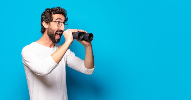 Young crazy bearded man with binoculars