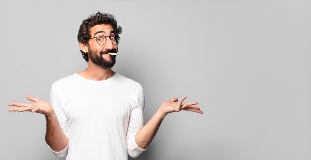 Young crazy bearded man with a cigarette. no smoking\
concept.