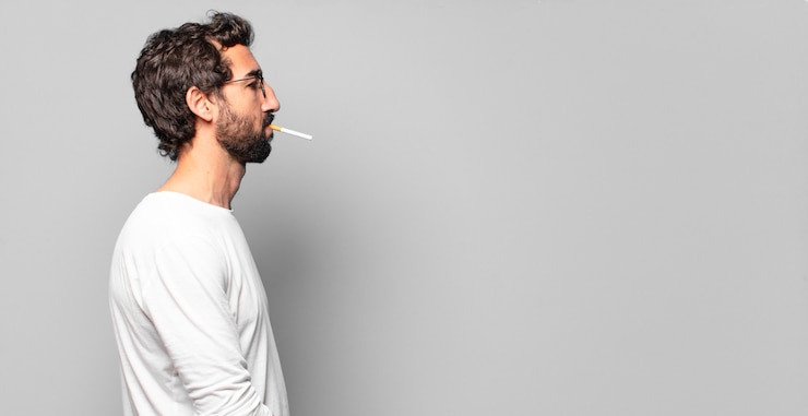 Photo young crazy bearded man with a cigarette.