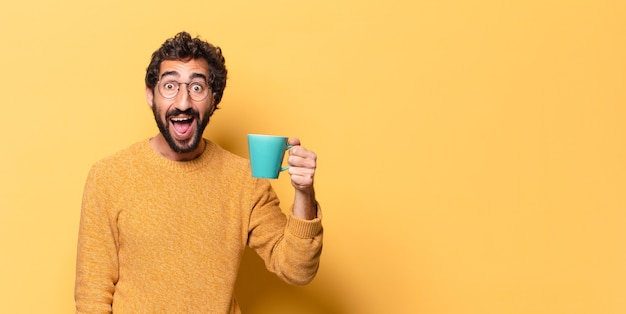 Young crazy bearded man with a coffee cup