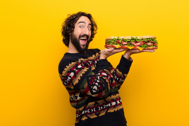 Young crazy bearded man with a giant sandwich