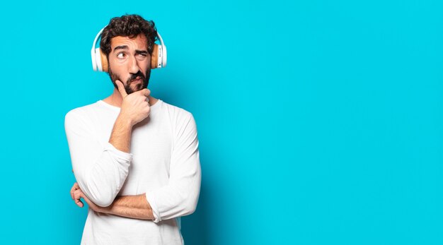 Young crazy bearded man with headphones listening music