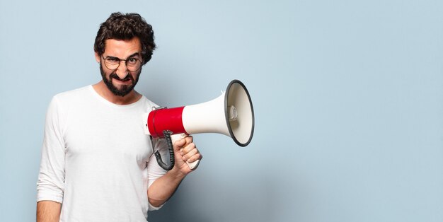 Young crazy bearded man with a megaphone