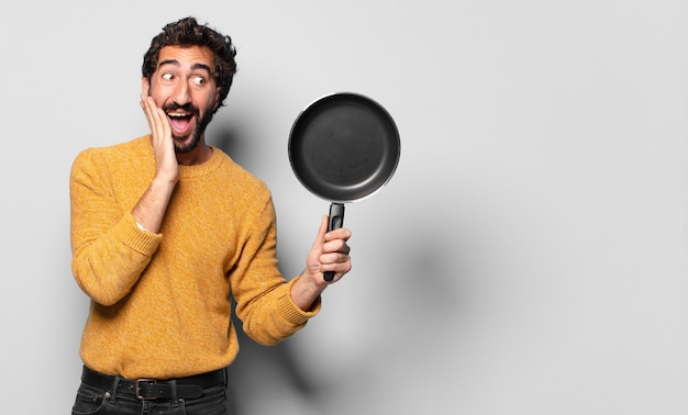 Young crazy bearded man with a pan