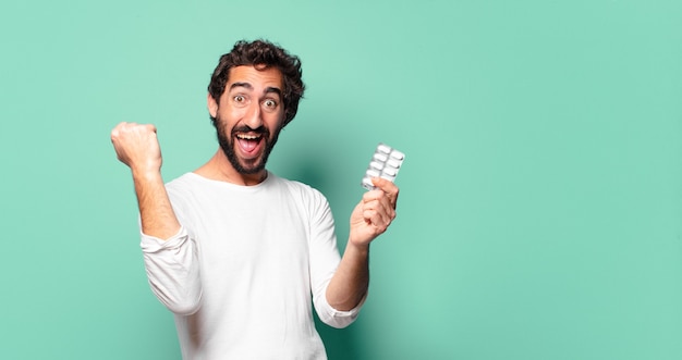 Young crazy bearded man with a pills tablet