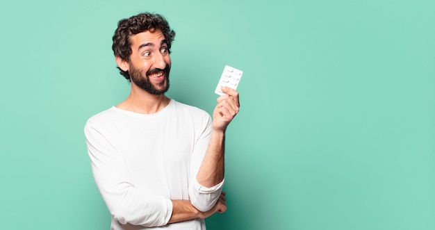 Young crazy bearded man with a pills tablet