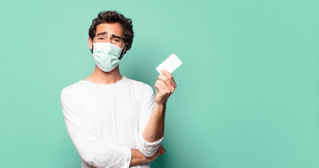 Foto giovane uomo barbuto pazzo con una compressa di pillole