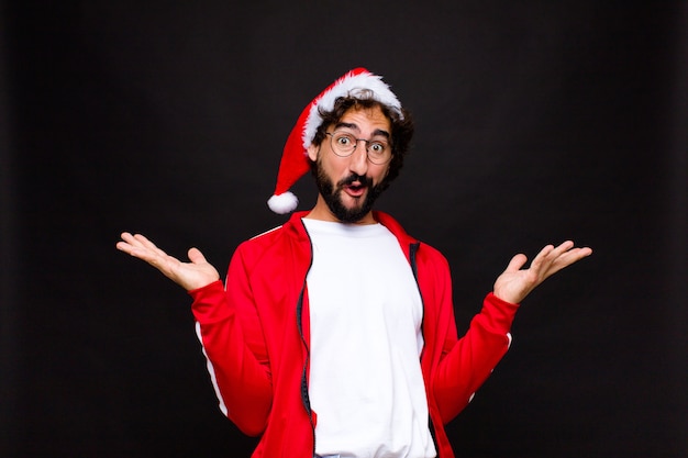 Young crazy bearded man with santa hat. Christmas concept