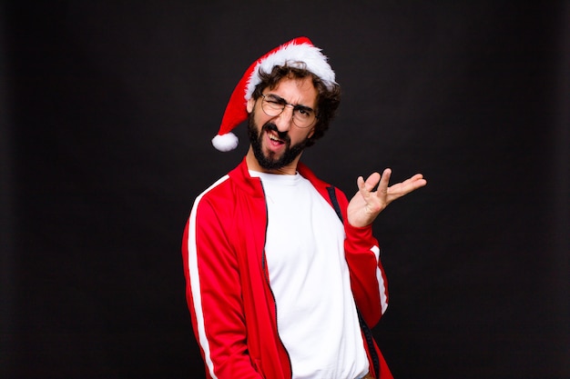 Young crazy bearded man with santa hat. Christmas concept