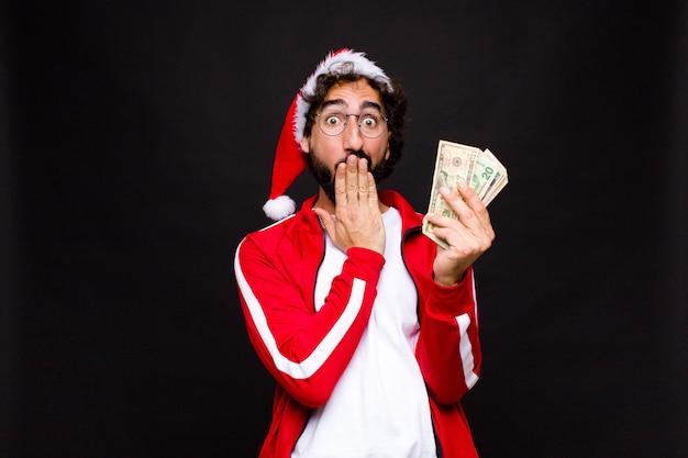 Young crazy bearded man with santa hat. Christmas concept