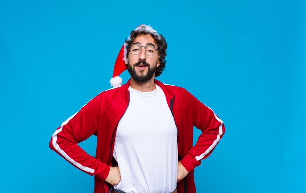 Young crazy bearded man with santa hat. Christmas concept