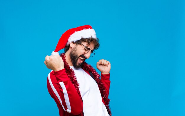 Young crazy bearded man with santa hat. Christmas concept