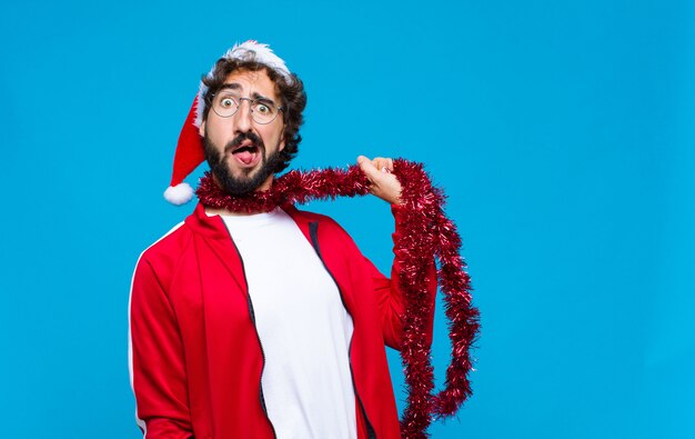 Young crazy bearded man with santa hat. Christmas concept