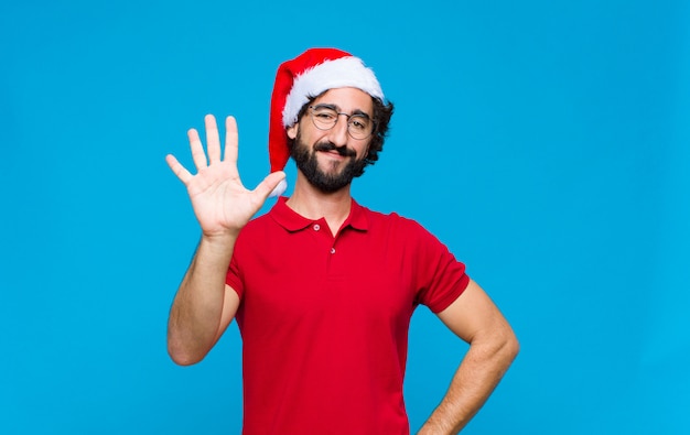 Young crazy bearded man with santa hat. Christmas concept