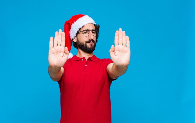 Young crazy bearded man with santa hat. Christmas concept