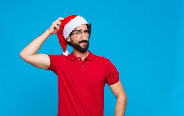 Young crazy bearded man with santa hat. Christmas concept