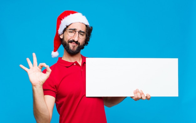 Young crazy bearded man with santa hat. Christmas concept