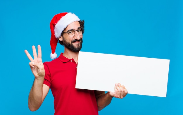 Young crazy bearded man with santa hat. Christmas concept